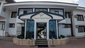 El exterior del Hotel Burgaz Resort, con un logo de estrella, una escalera que lleva a la entrada y un cielo despejado.