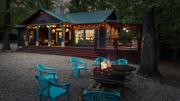 A lodge with a porch, outdoor seating, and a fire pit. - Holly Hill Secluded Retreat 7 acrs, Perfect 2 Bedroom, Hot Tub, Pets (Broken Bow)