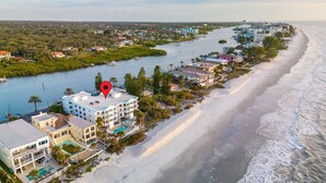 Eine Vogelperspektive eines Küstenhotels mit mehreren Gebäuden, einem Strand und einem Fluss.