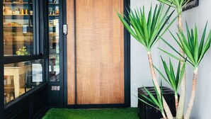 Un bâtiment moderne avec une façade en briques, une porte en bois et un pot de fleurs.