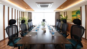 A conference room with a long table, chairs, water bottles, and a decorative centerpiece.