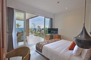 A bedroom with a bed, a TV, and a view of the ocean. - Rajavilla Lombok Resort (Senggigi)