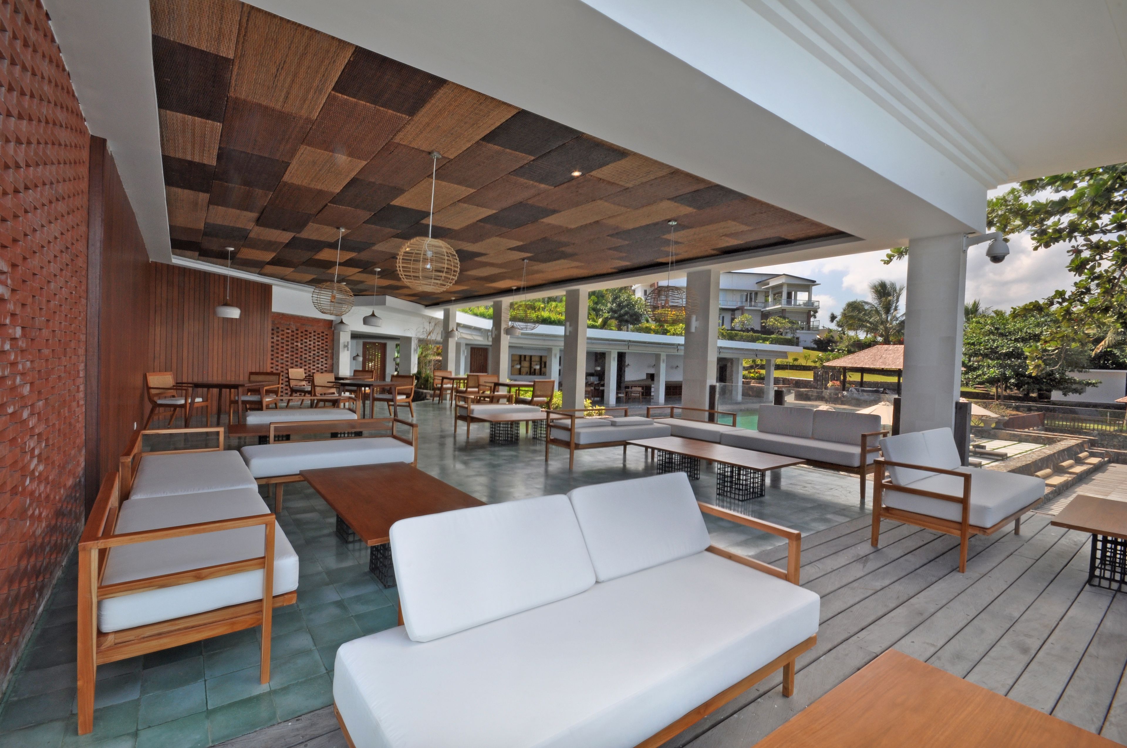 An outdoor seating area with wooden furniture and a checkered ceiling.