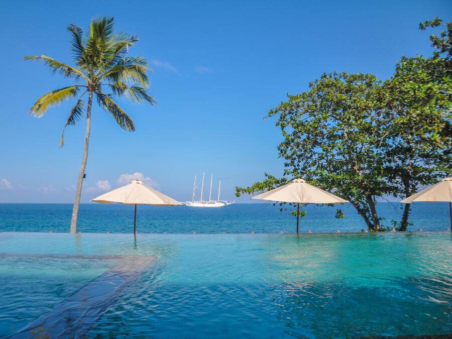 Een buitenzwembad, ligstoelen bij het zwembad