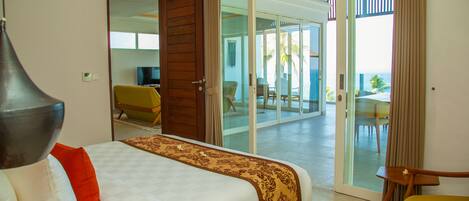 A hotel room with a bed, a chair, and a view of the outside.