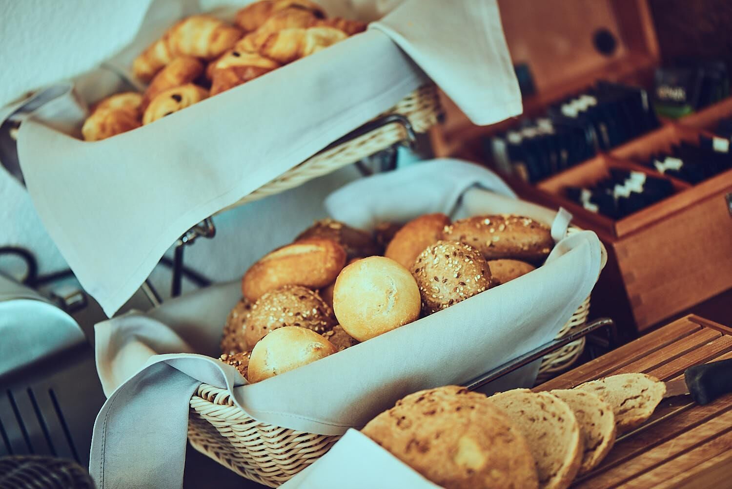 Two baskets of assorted bread and pastries.