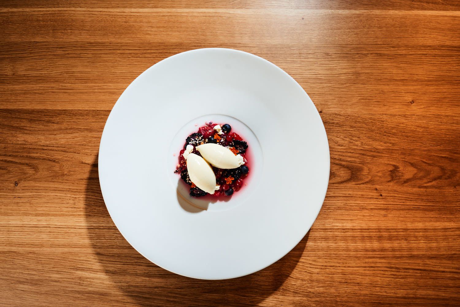 A white plate with a dessert on a wooden table.