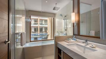Un baño moderno con un espejo grande, dos lavamanos y una ducha.