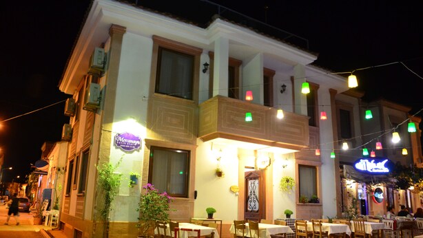 A two-story building with outdoor seating, a visible restaurant sign, and a balcony with hanging lights. - Mercanay Butik Otel (Ayvalik)