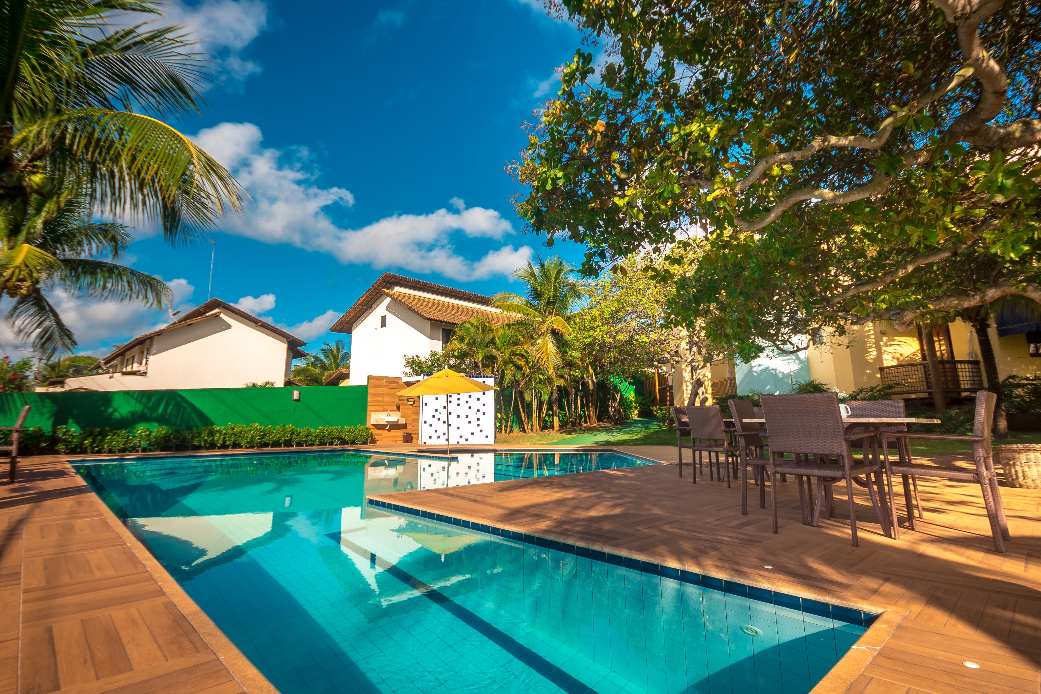 Una piscina al aire libre, sombrillas, sillones reclinables de piscina