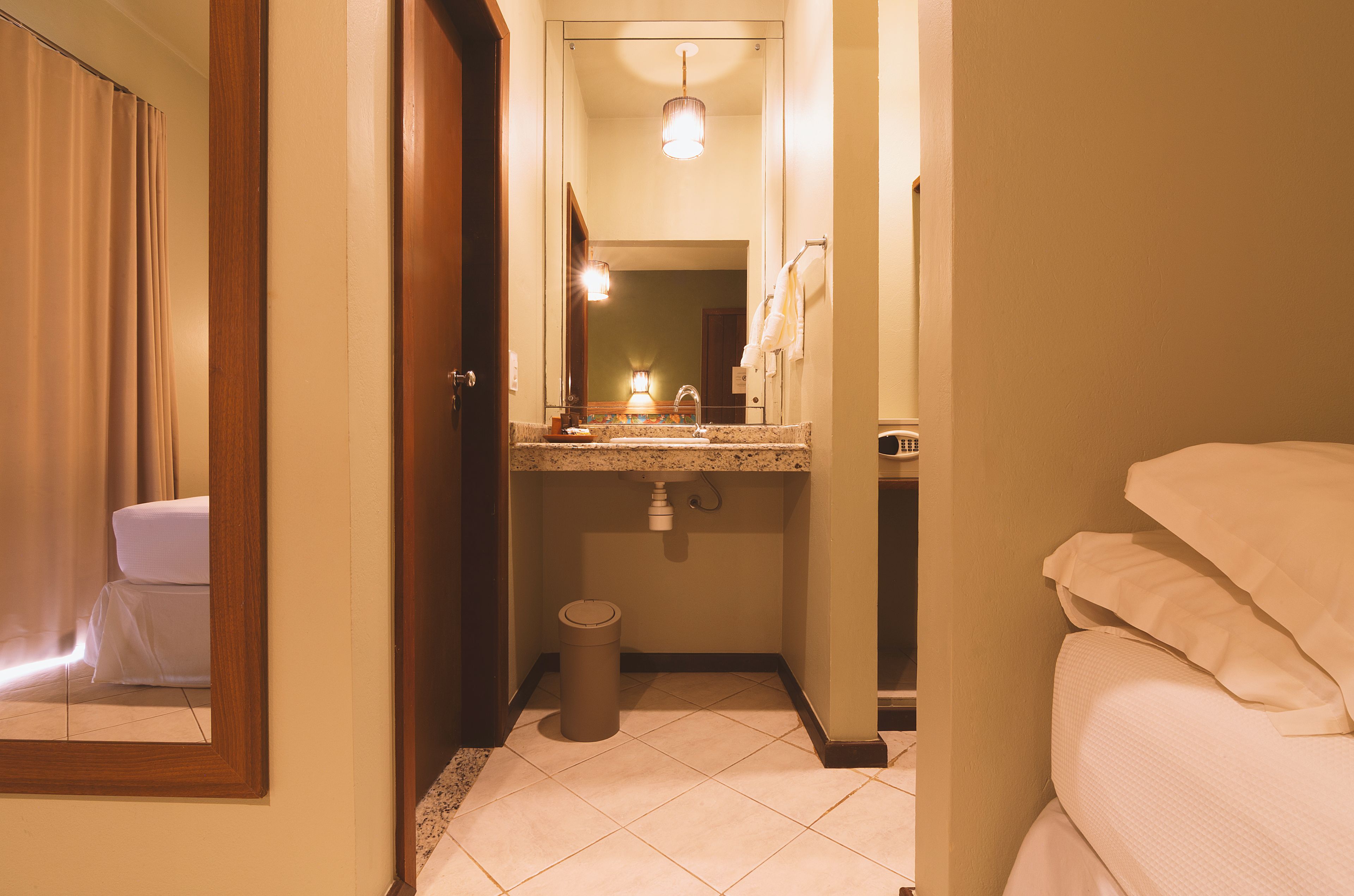 Une salle de bain d’hôtel avec un lavabo, un miroir et des toilettes.
