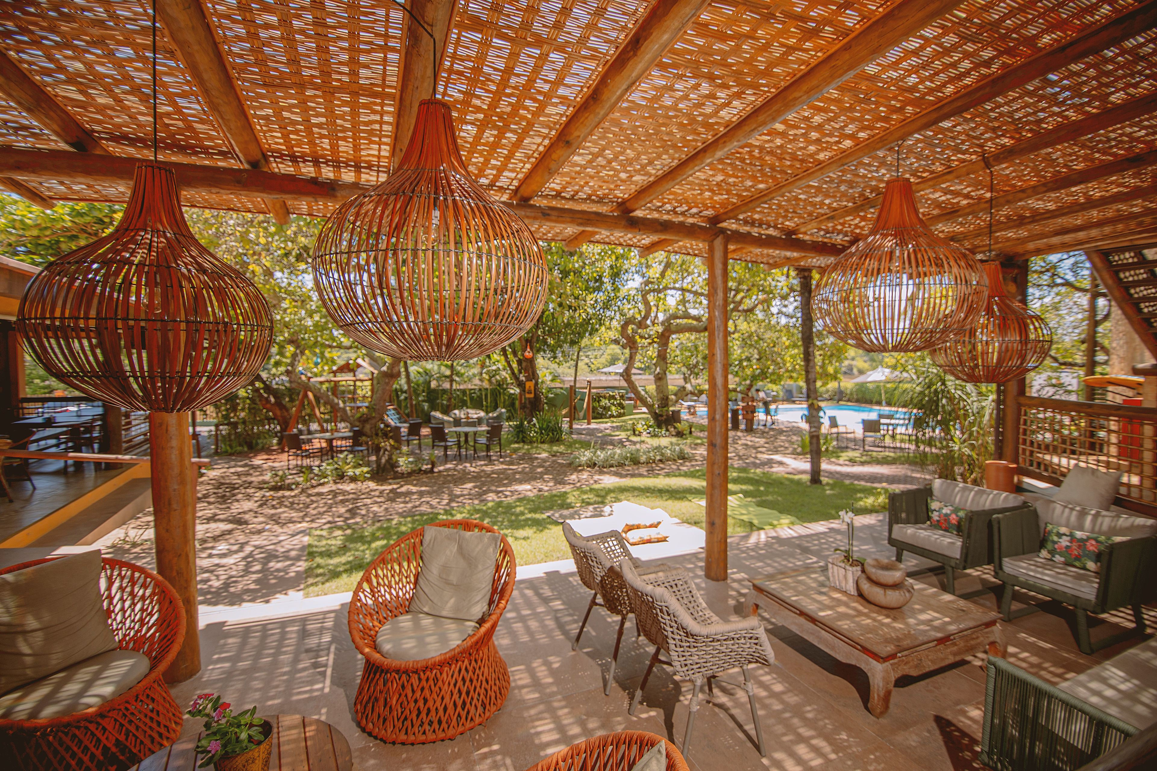 An outdoor seating area with wicker furniture and hanging light fixtures.
