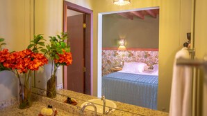 Een badkamer met een wastafel, spiegel en twee bloemen vazen.