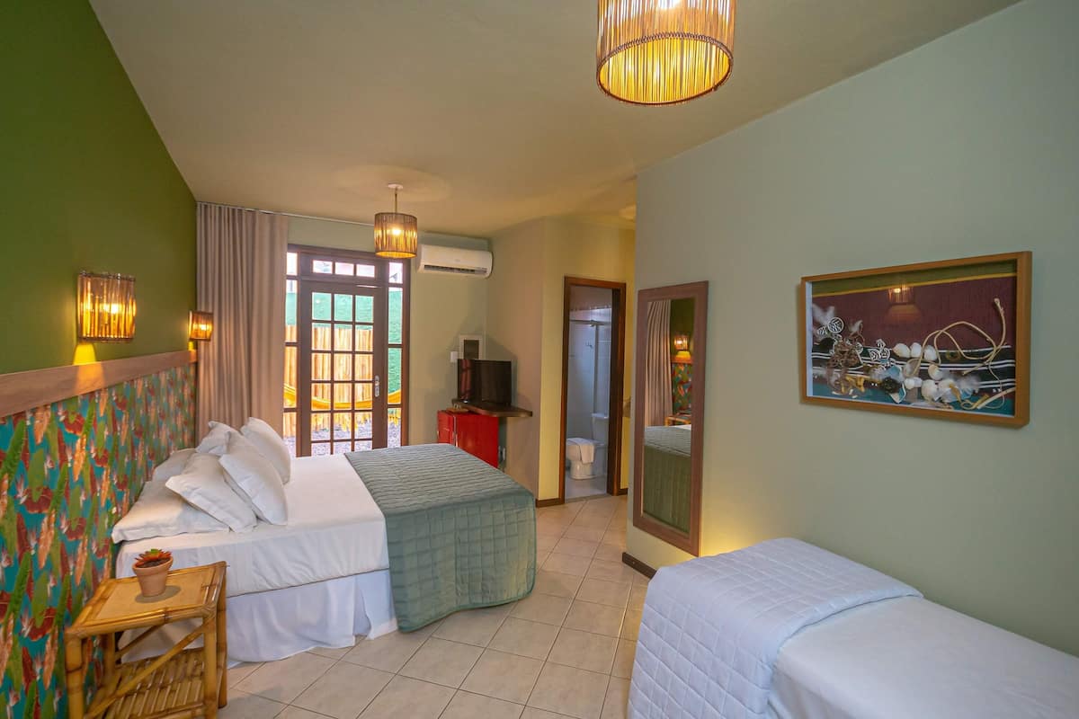 Een hotelkamer met twee bedden, een televisie, een spiegel en een schilderij aan de muur.