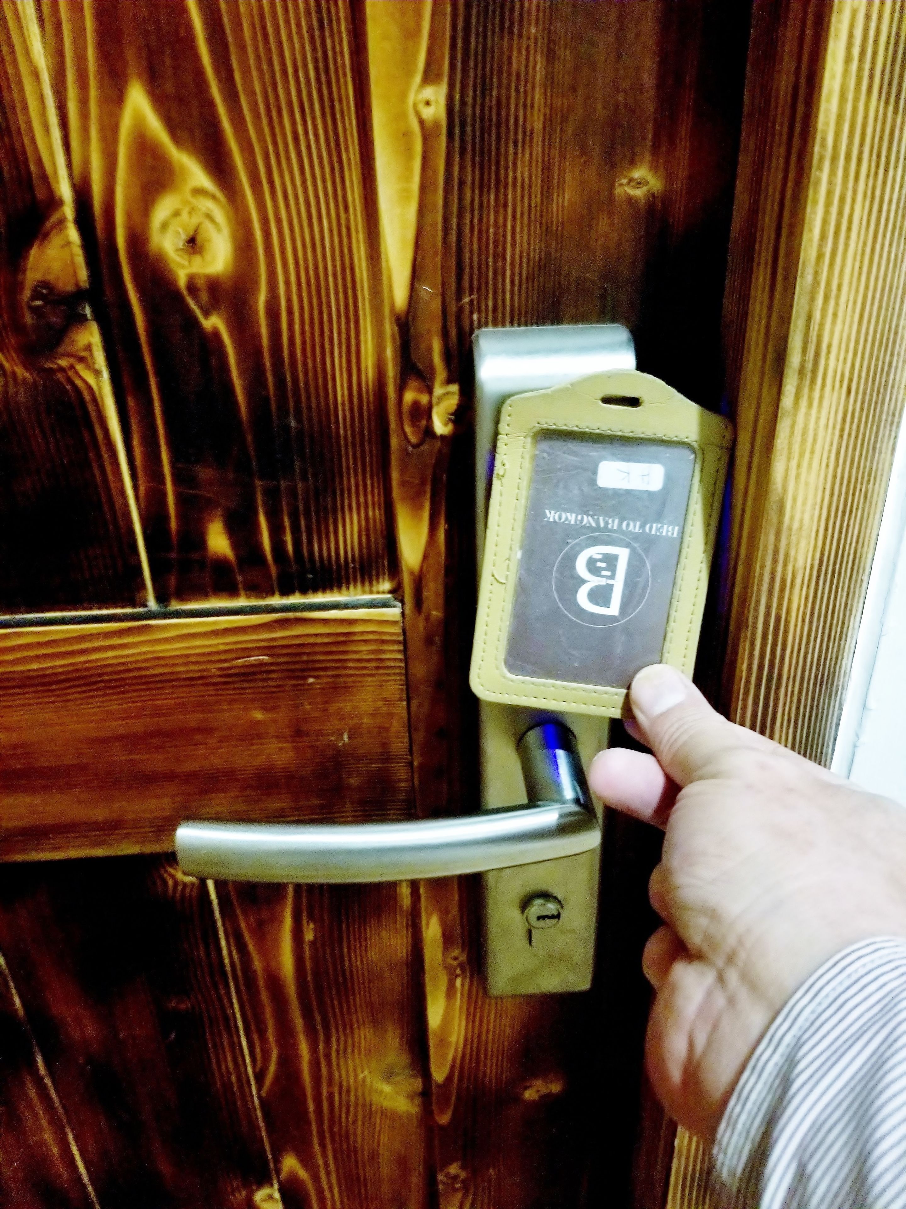 Una mà insereix una clau en la serradura d'una porta.