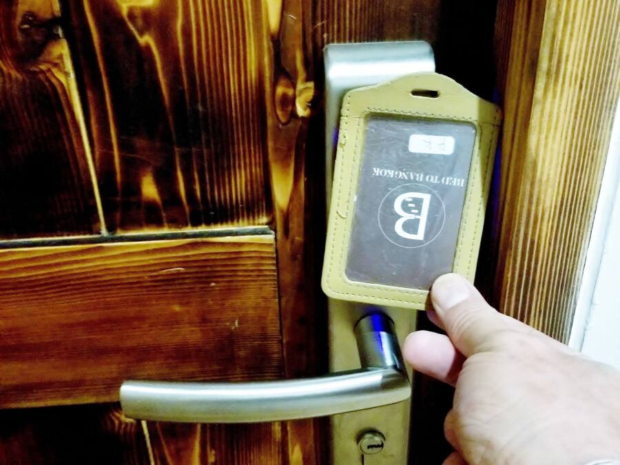 Una mà insereix una clau en la serradura d'una porta.