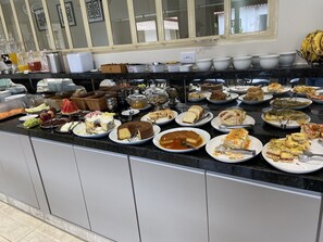 Un bufé con diversos platos, incluyendo pasteles, frutas y ensaladas.