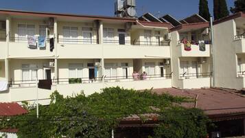 Un edificio residencial de varios pisos con balcones, aire acondicionado y ropa tendida.