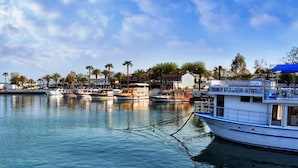 A marina with several boats docked, a waterfront view, and buildings in the background. - Derya Motel (Manavgat)