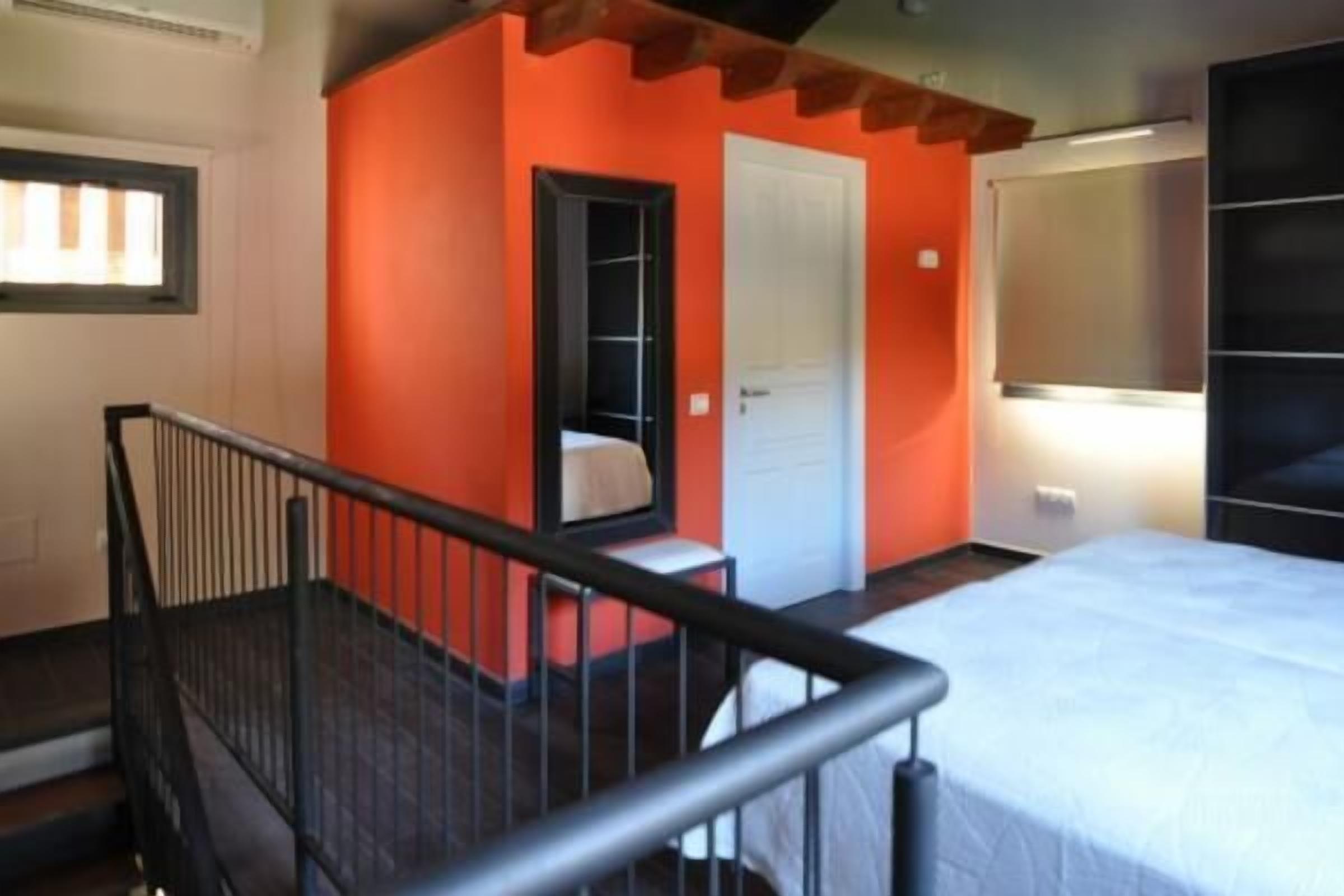 Une chambre à coucher avec un lit, une porte blanche et une armoire noire.