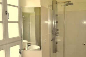 Ein Badezimmer mit Duschkabine, Toilette und Waschbecken.