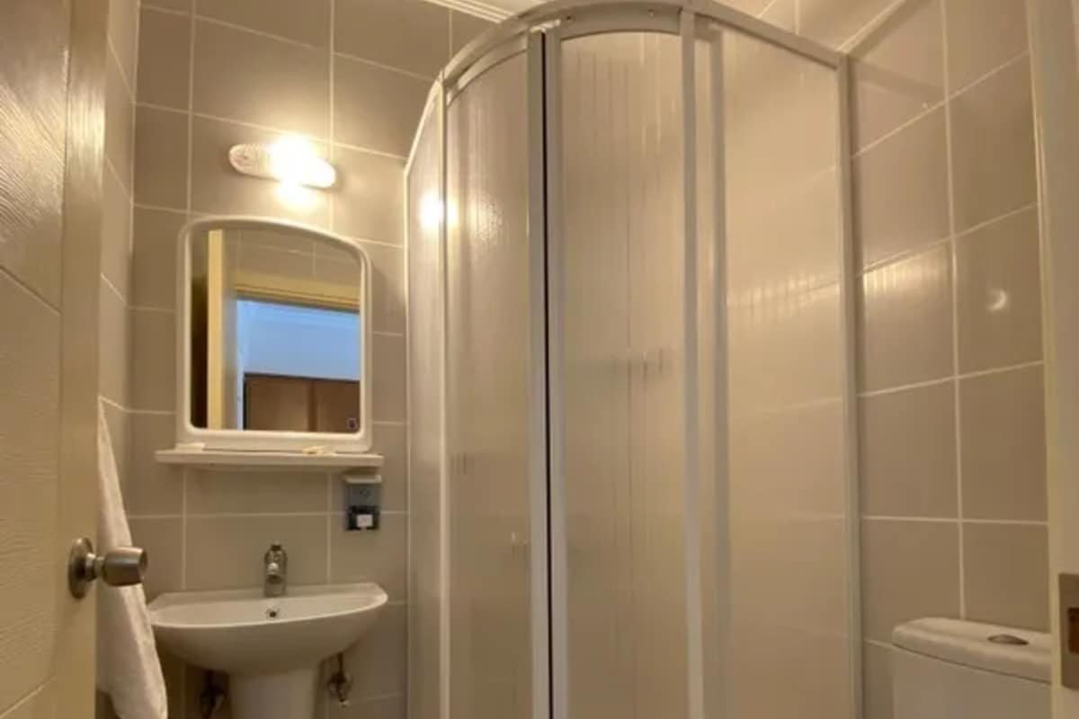 Un baño con cabina de ducha, lavabo e inodoro.