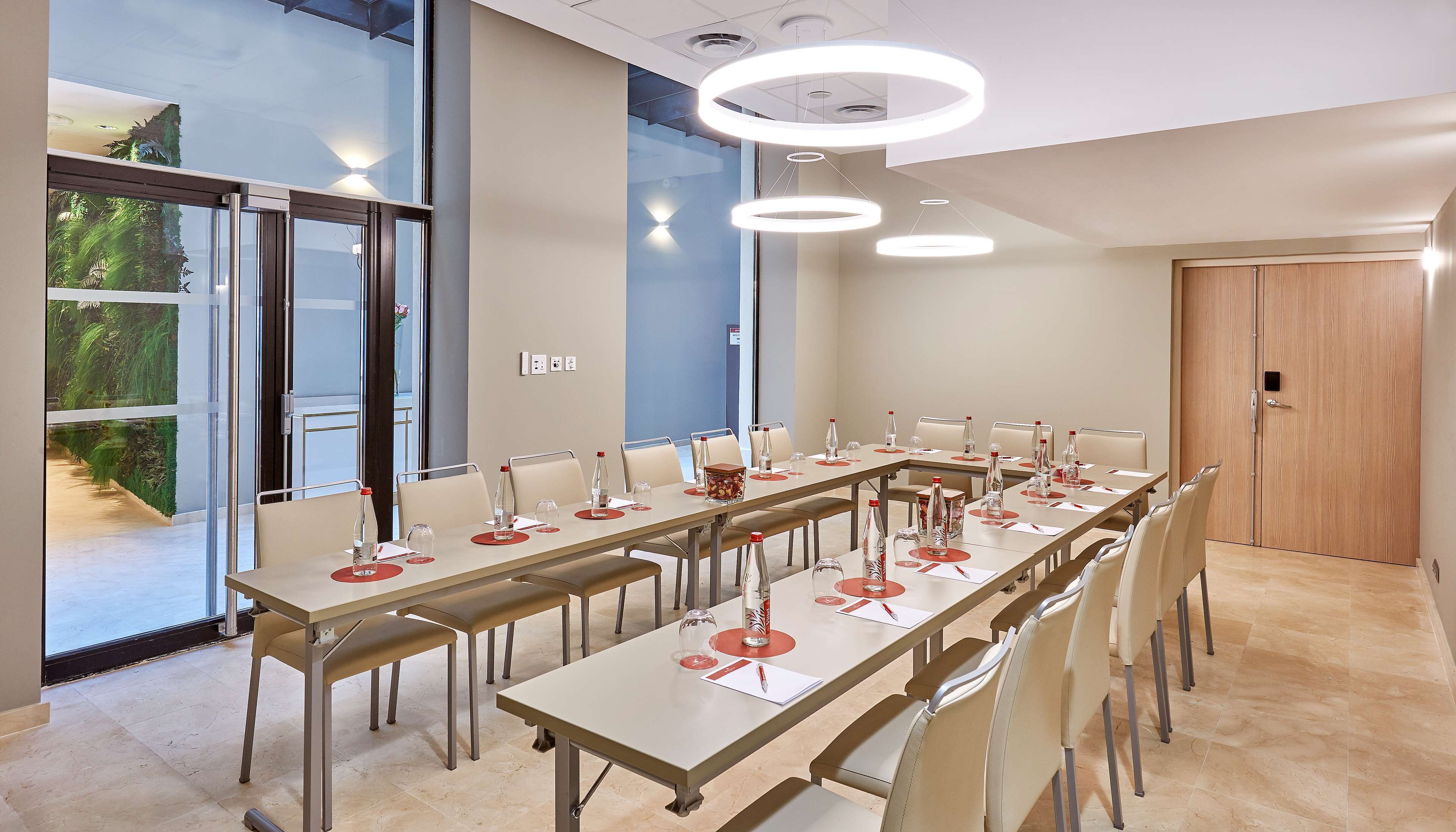A conference room with long tables, chairs, and modern lighting fixtures.