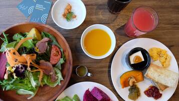 Una mesa con diversos platos, incluyendo una ensalada, sopa y un plato con pan y fruta.