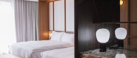 Quarto de hotel com uma cama grande, cabeceira de madeira, bancada de mármore e um espelho.
