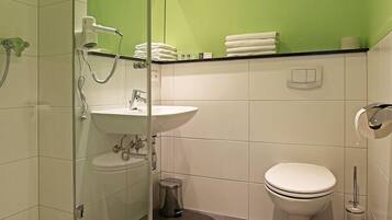 Ein modernes Badezimmer mit Duschkabine aus Glas, einem weißen Waschbecken, einer Toilette und einer Badewanne.