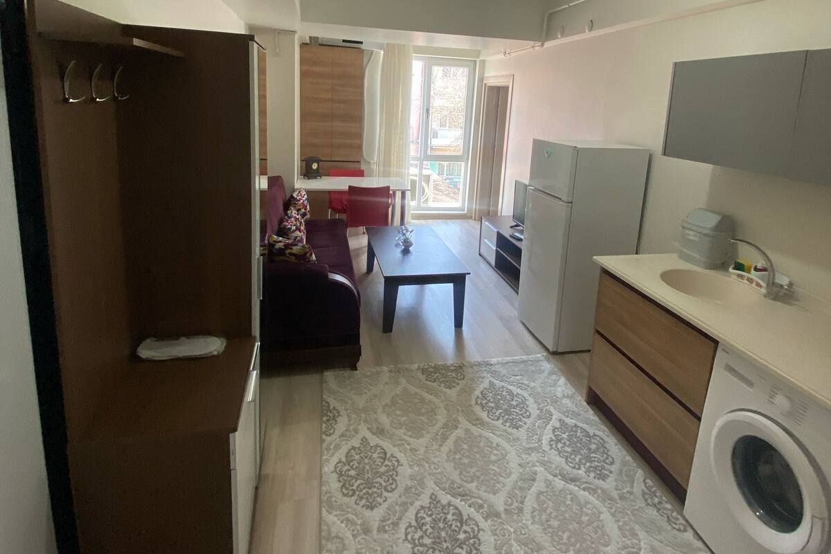A compact living space with a kitchenette, a dining area, and a small seating area.
