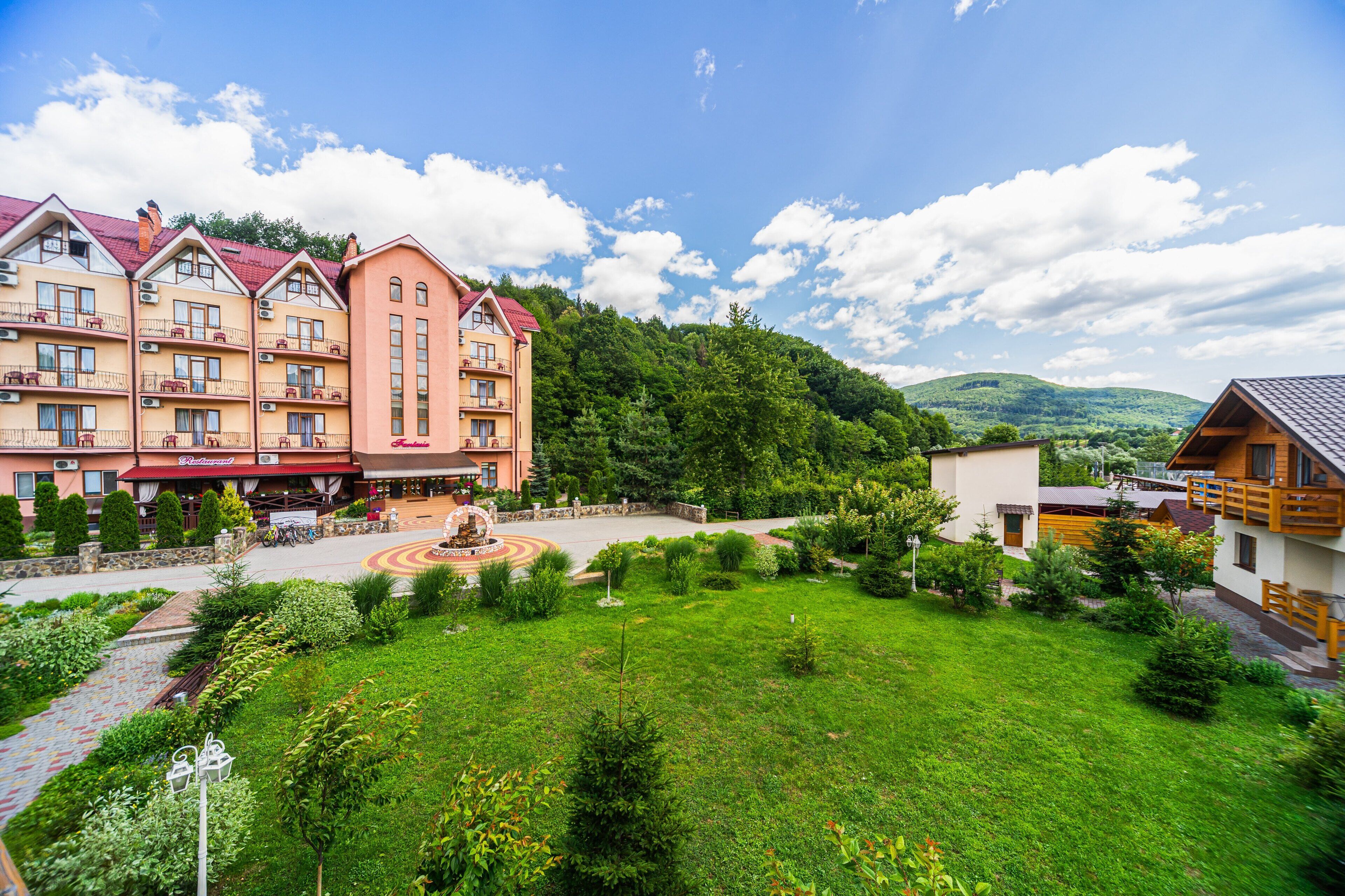 Un hôtel à étages, doté d’une cour intérieure et situé dans un cadre montagneux.