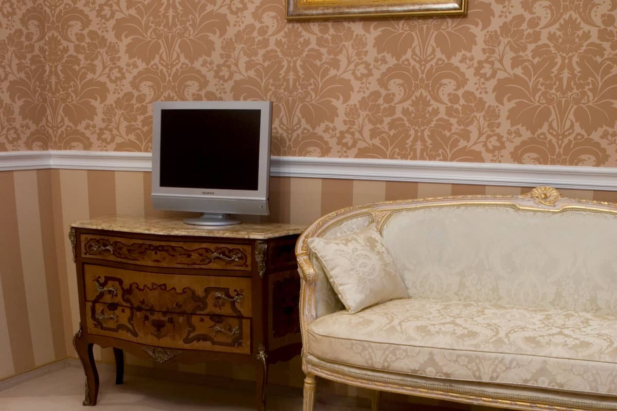 A room with a vintage sofa, a wooden side table, and a round coffee table.