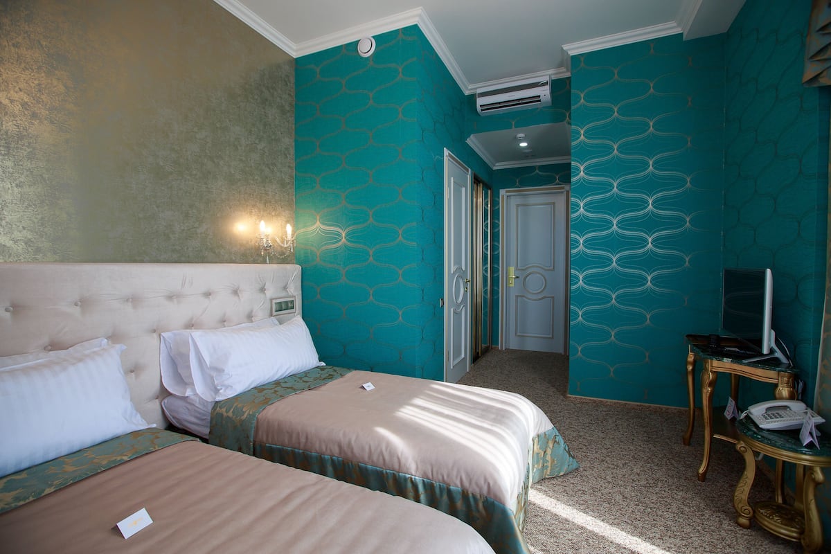 A hotel room with two beds, a television, and a small table.