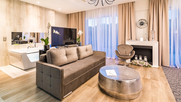 A modern living room with a sofa, a round coffee table, a TV, and a fireplace.