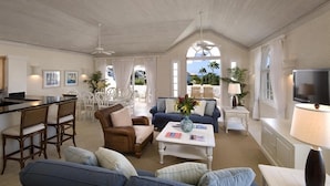 A spacious living area with a dining set, a sofa, a coffee table, and a TV. - Villa -Westmoreland (Westmoreland)