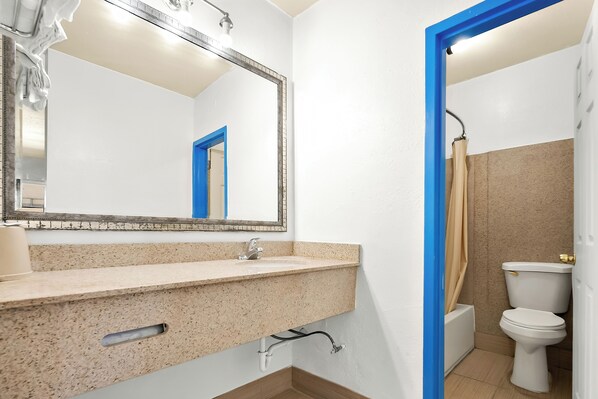 A bathroom with a sink, mirror, and toilet.