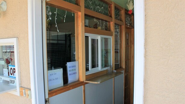 Una recepción con un cartel de 'No se admiten perros', un cartel de 'Cuidado al caer' y un cartel de 'Salida'.