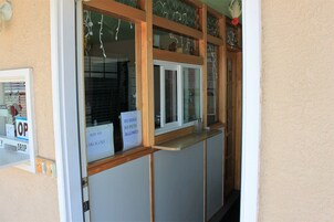 Una recepción con un cartel de 'No se admiten perros', un cartel de 'Cuidado al caer' y un cartel de 'Salida'.