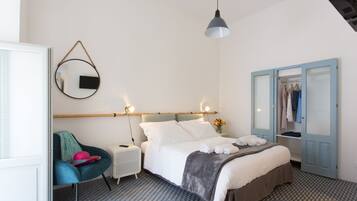 Un dormitorio con cama, mesita de noche, silla y armario.