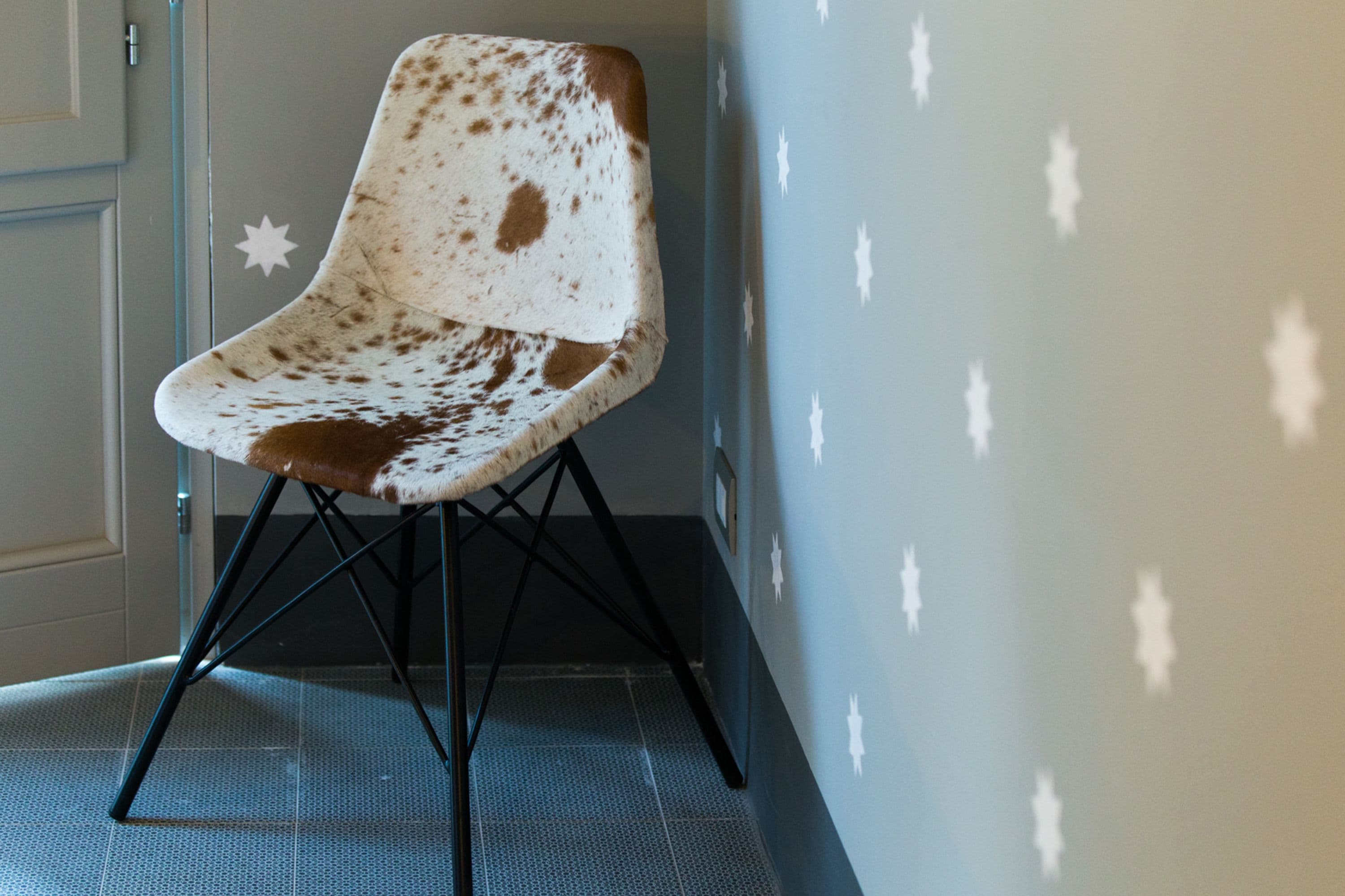 Una silla de diseño peculiar, ubicada frente a una pared decorada con estrellas.