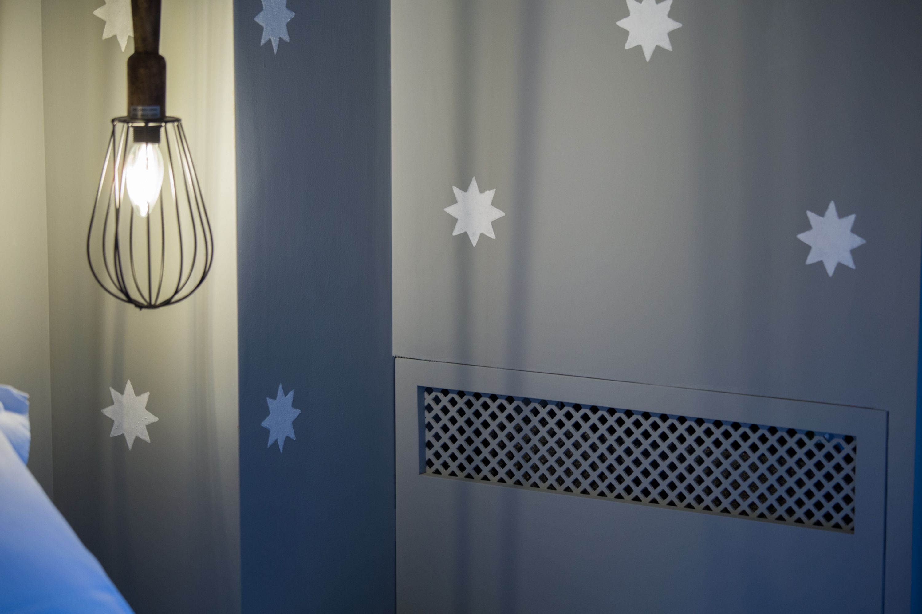 A room with a hanging light fixture and star-shaped wall decorations.