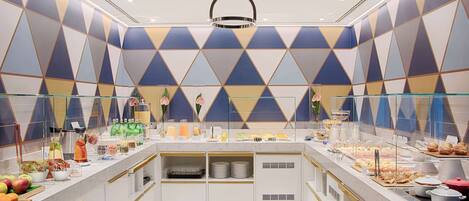 A buffet with a geometric wall pattern, a glass display case, and a ceiling light fixture.