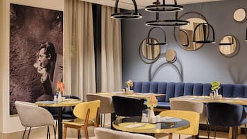 Un comedor moderno con mesas redondas, sillas y un sofá azul.