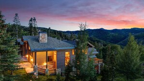 A log cabin with a stone chimney, wooden exterior, and a porch with a railing. - Lucky Star At Belle Arbor 4 Bedroom Home by RedAwning (Park City)