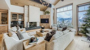A modern living room with a fireplace, large windows, and a view of a snowy mountain. - Lucky Star At Belle Arbor 4 Bedroom Home by RedAwning (Park City)