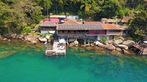 A restaurant with a clear view of the surrounding water and rocks. - Pousada Convés Ilha Grande (Angra dos Reis)