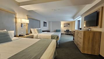 Une chambre d’hôtel avec deux lits, un bureau, une télévision et un minibar.