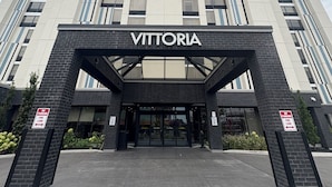 Een modern gebouw met de naam 'VITTORIA' duidelijk zichtbaar bij de ingang.