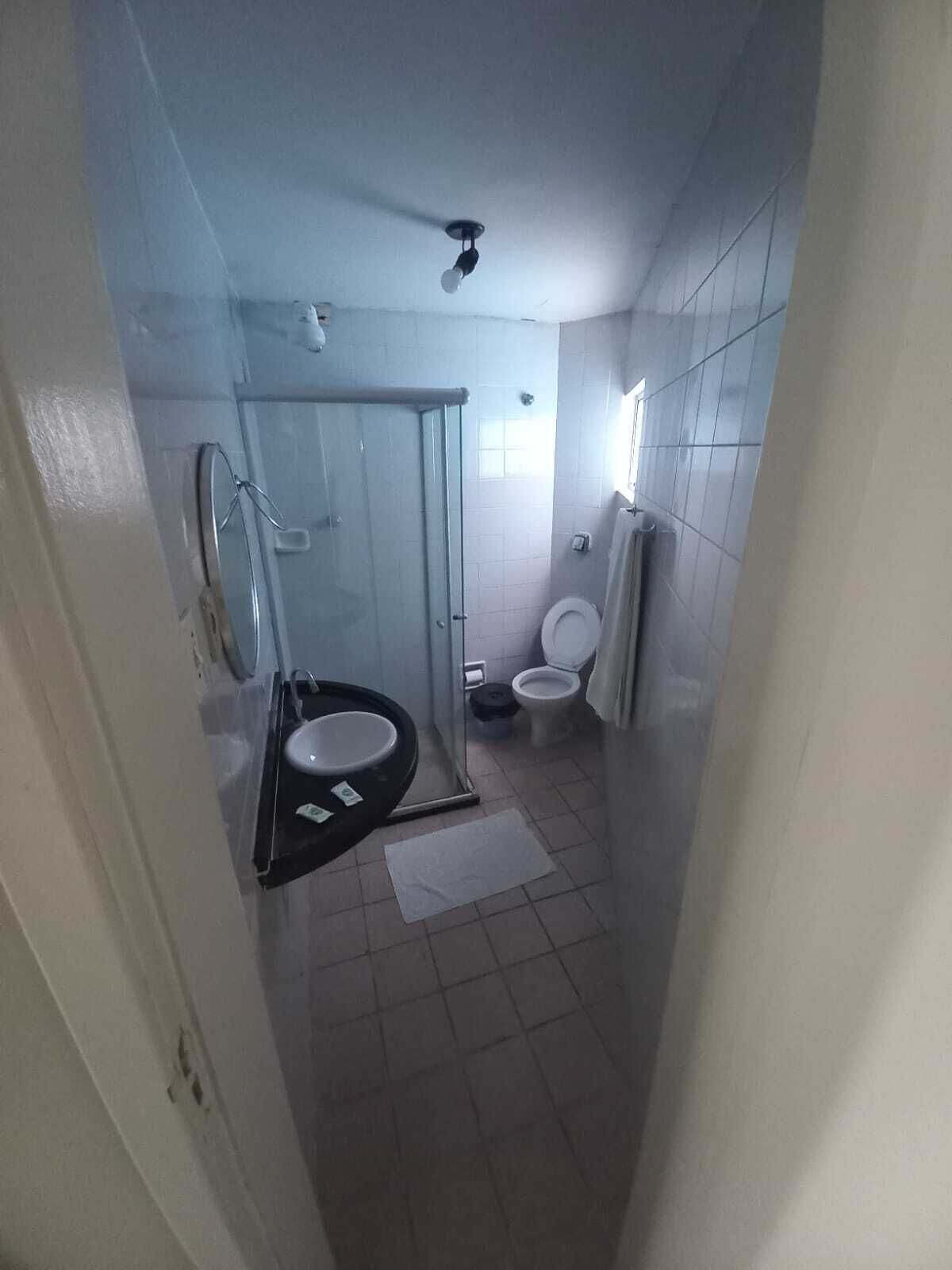 A compact bathroom with a shower enclosure, a toilet, and a sink.